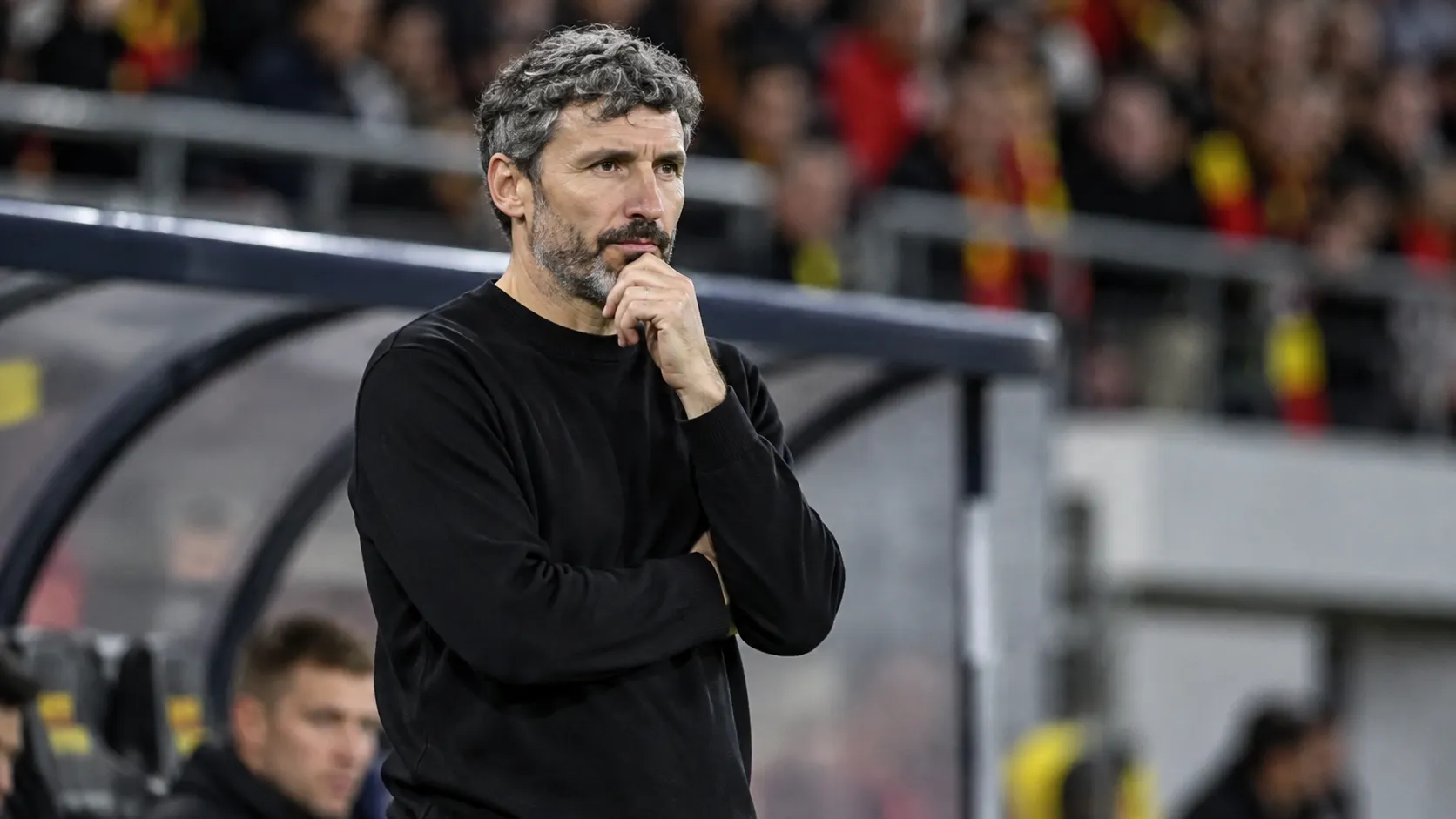 Mark van Bommel in zwarte trui langs de zijlijn bij een interland van België.