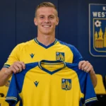 Nikola Storm toont als speler van KVC Westerlo een shirt tijdens een officiële clubpresentatie.