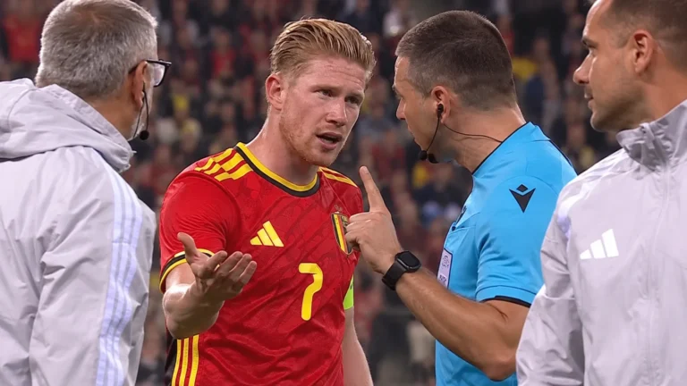 Kevin De Bruyne bespreekt een beslissing met de scheidsrechter aan de zijlijn.