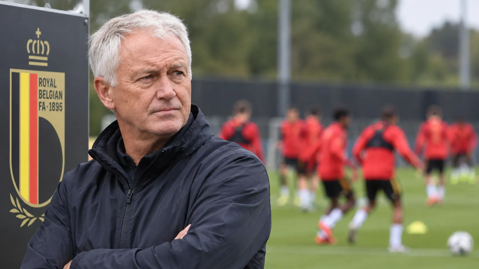 Een staflid observeert een oefensessie van België naast een vast bord van de Belgische voetbalbond.