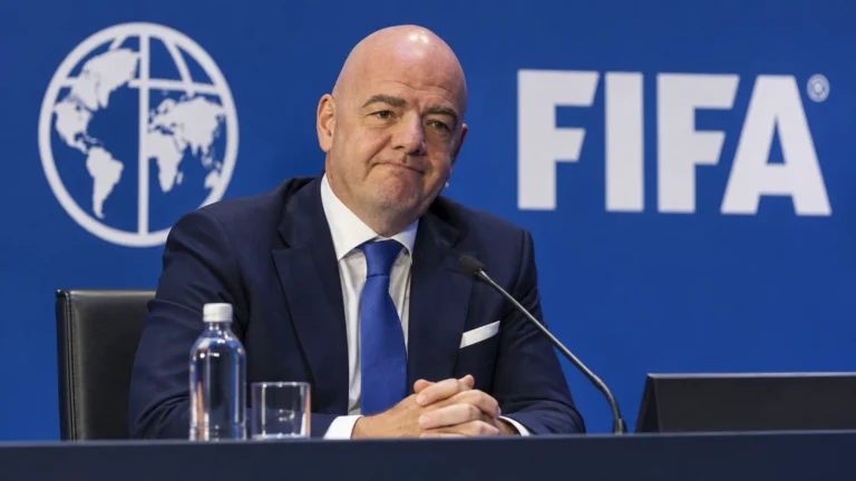 Een niet-spelende official in donker pak tijdens een FIFA-conferentie.