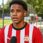 Noah Fernandez in PSV-shirt tijdens een rustig media-interview naast het veld.