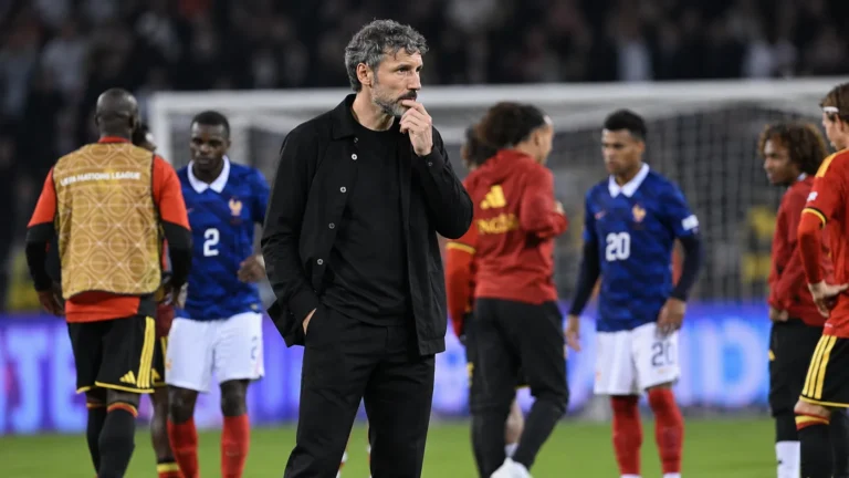 Mark van Bommel volgt de wedstrijd vanaf de zijlijn, met spelers op de achtergrond.