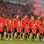 Belgische internationals en jonge mascottes tijdens het volkslied in een gevuld stadion.