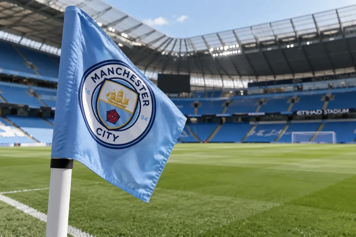 Een Manchester City-hoekvlag met het clubembleem naast het veld in een leeg stadion.
