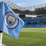Een Manchester City-hoekvlag met het clubembleem naast het veld in een leeg stadion.