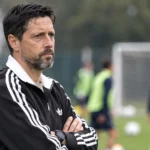 Een niet-spelende clubmedewerker kijkt vanop de zijlijn naar een training van Anderlecht.