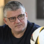 Philippe Albert tijdens een rustig voetbalinterview in een binnenruimte.