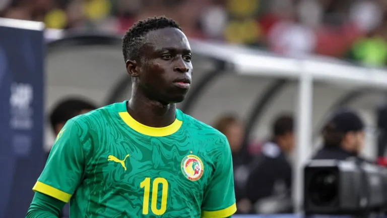 Krépin Diatta in groen Senegal-tenue langs het veld.