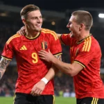 Belgische U21-spelers vieren samen tijdens een avondwedstrijd.