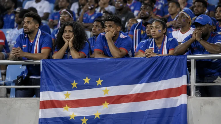 Een groep supporters van Kaapverdië zwaait met een nationale vlag in het stadion.