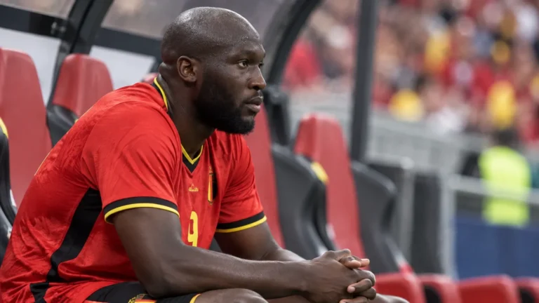 Romelu Lukaku zit in het rode tenue van België op de bank tijdens een interland.