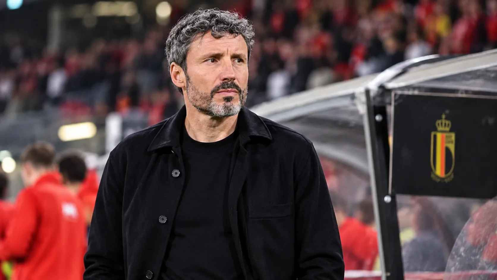 Mark van Bommel staat in de technische zone naast een vast bord met het embleem van de Belgische voetbalbond.