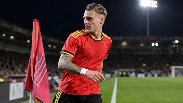Norman Bassette van de Jonge Duivels bij een hoekvlag tijdens een avondwedstrijd.