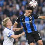 Een Club Brugge-speler kopt de bal tijdens een wedstrijdduel.