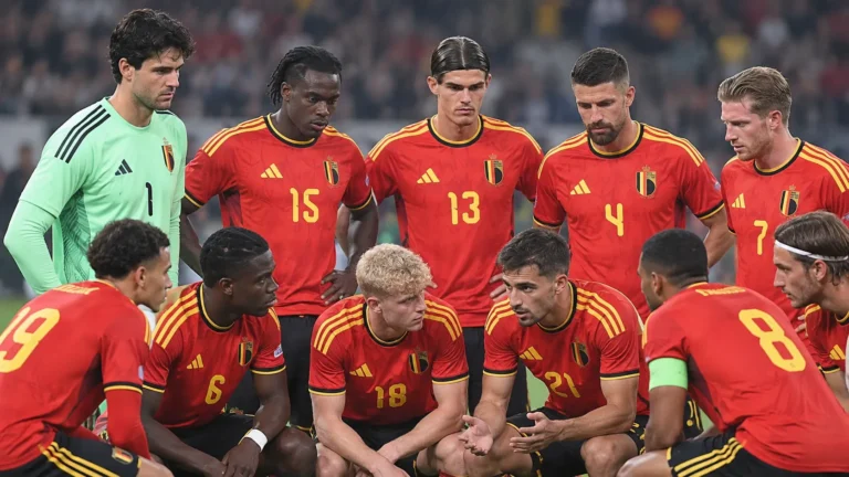 Een groep Belgische internationals in rode nationale tenues verzameld op het veld.