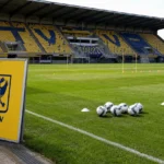 Leeg trainingsveld op Stayen met een geel STVV-trainingsbord langs de zijlijn.