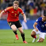 Kevin De Bruyne in een rood Belgisch shirt tijdens een duel om de bal.
