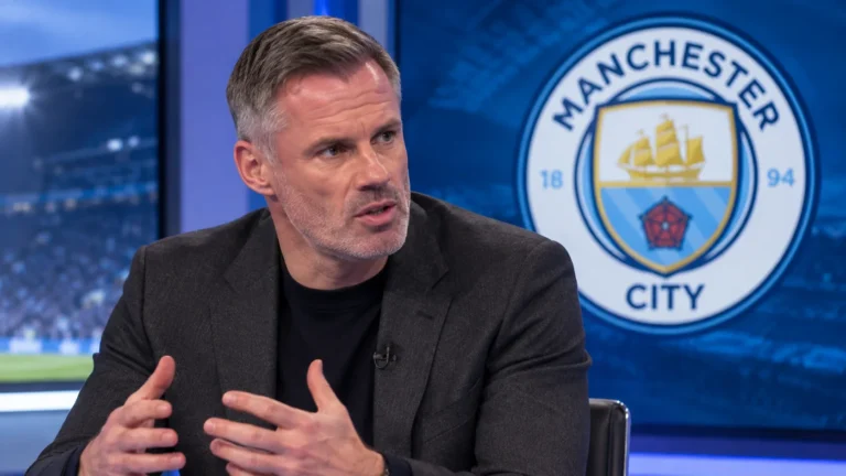 Jamie Carragher spreekt in een televisiestudio met een Manchester City-embleem op een scherm achter hem.