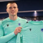 Tobe Leysen poseert tijdens een officiële presentatie in het doelmanstenue van KRC Genk.