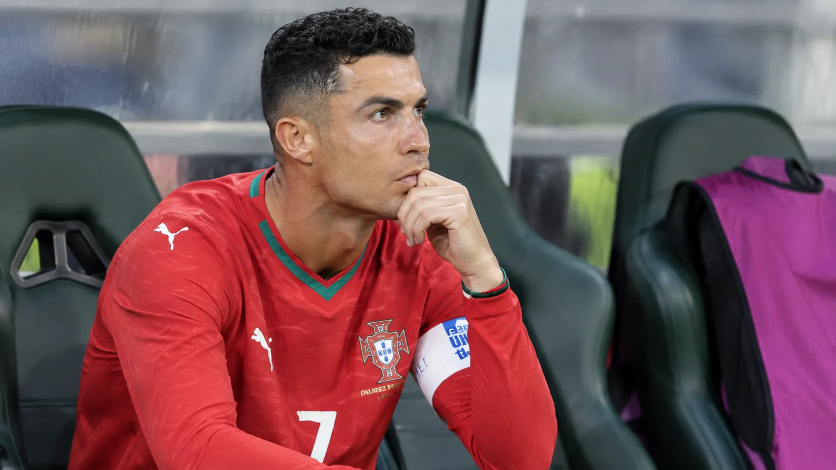 Cristiano Ronaldo zit op de bank in het Portugese wedstrijdtenue.