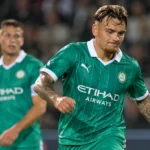 Twee voetballers in groene tenues tijdens een oefenwedstrijd.