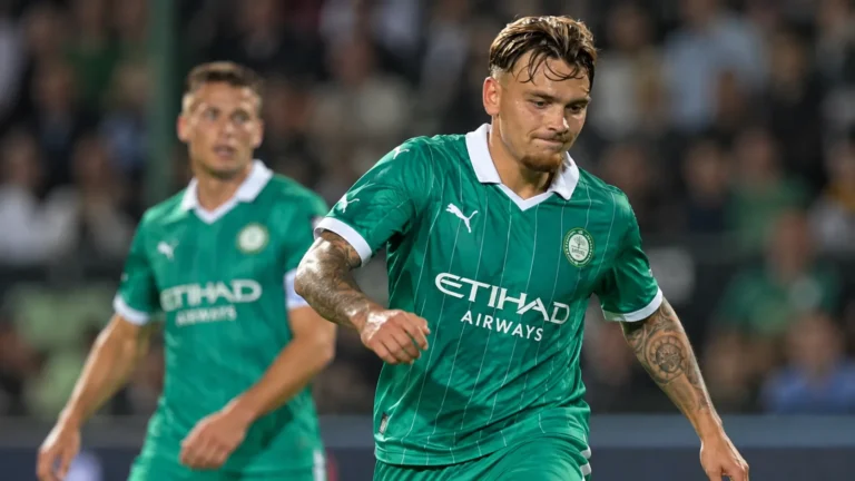 Twee voetballers in groene tenues tijdens een oefenwedstrijd.