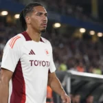 Chris Smalling in een wit-bordeaux voetbaltenue langs het veld.