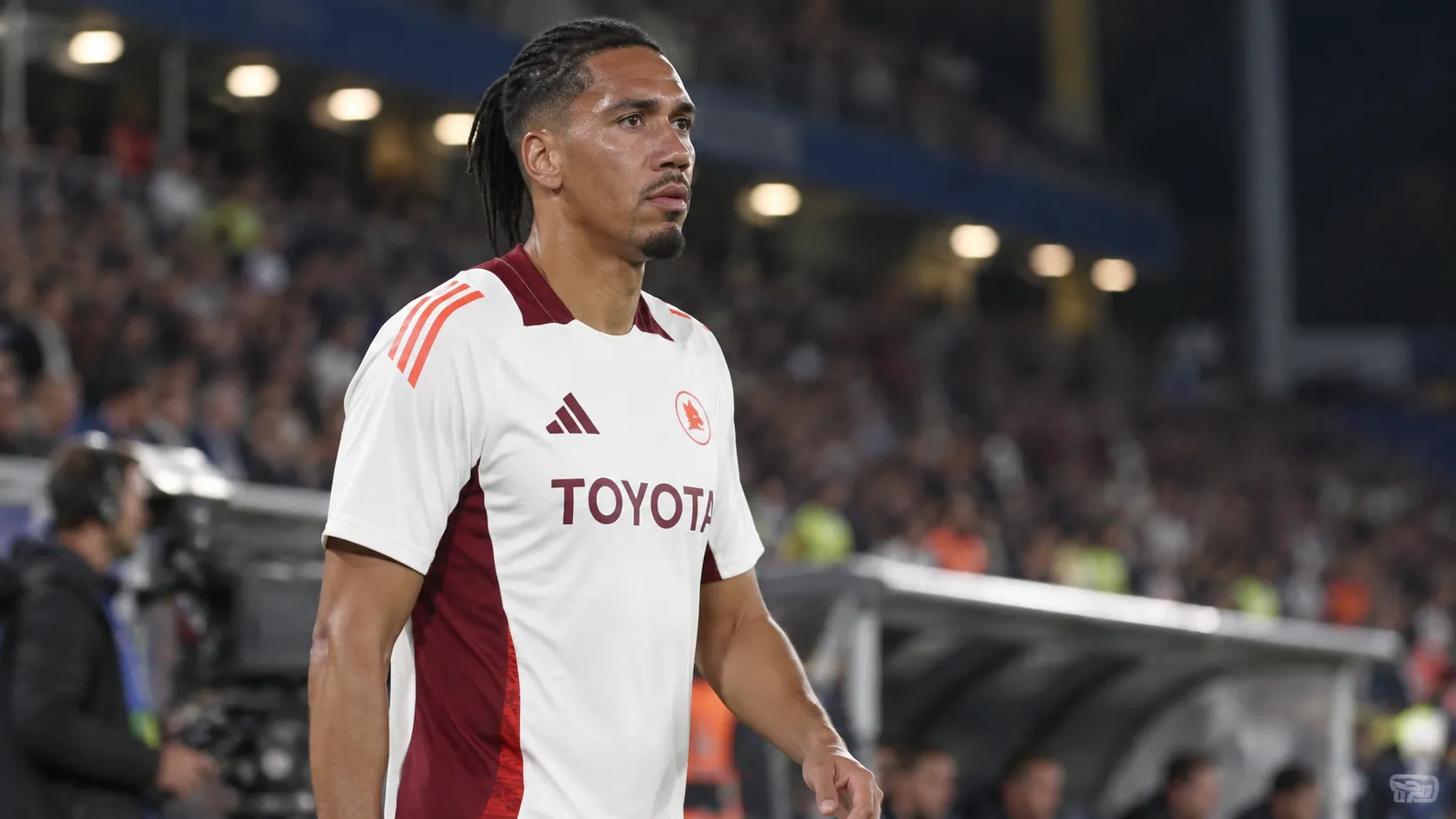 Chris Smalling in een wit-bordeaux voetbaltenue langs het veld.
