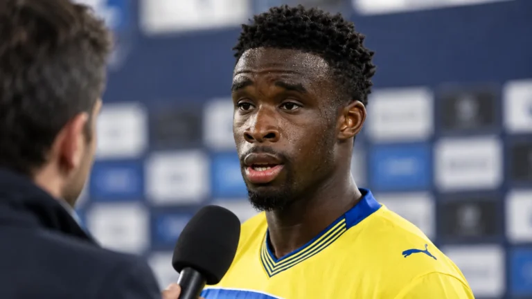 Mandela Keita tijdens een interview in zijn gele voetbalshirt.