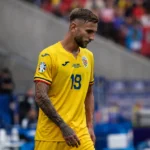 Denis Draguș in het gele shirt van Roemenië naast de zijlijn van een voetbalstadion.