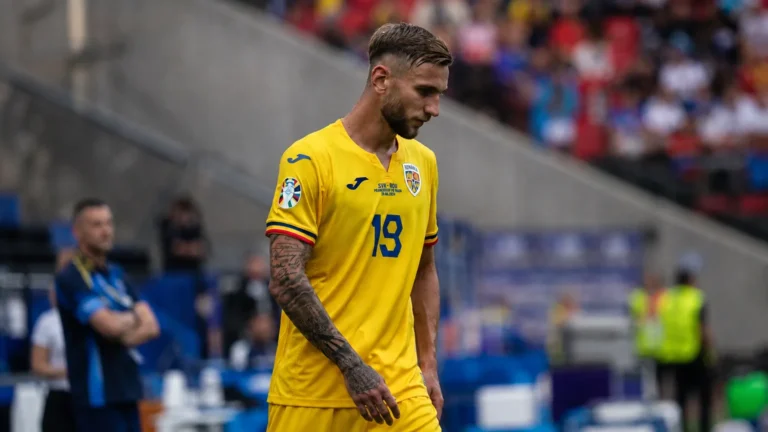 Denis Draguș in het gele shirt van Roemenië naast de zijlijn van een voetbalstadion.