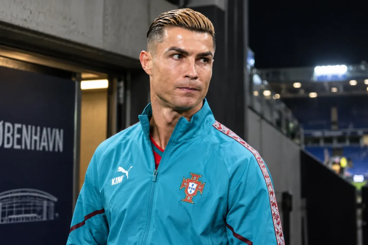 Cristiano Ronaldo in een trainingsjas van Portugal bij een stadionuitgang.