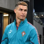 Cristiano Ronaldo in een trainingsjas van Portugal bij een stadionuitgang.