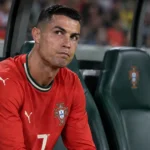 Cristiano Ronaldo zit geconcentreerd op de bank bij Portugal tijdens een Nations League-wedstrijd.