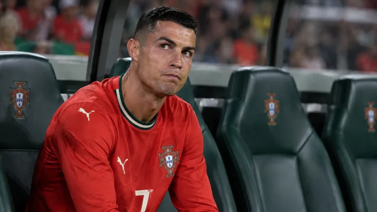 Cristiano Ronaldo zit geconcentreerd op de bank bij Portugal tijdens een Nations League-wedstrijd.