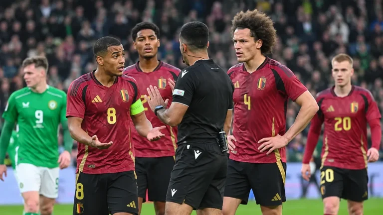 Een scheidsrechter in gesprek met Belgische internationals tijdens een interland.