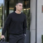 Cristiano Ronaldo in neutrale reiskleding bij de ingang van het trainingscomplex van Portugal.