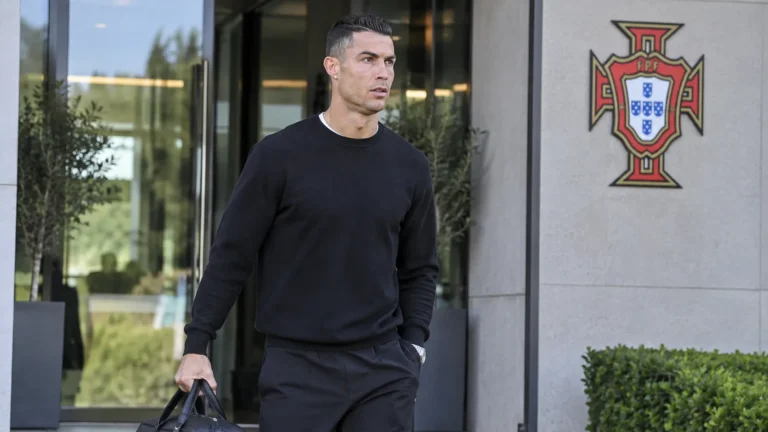 Cristiano Ronaldo in neutrale reiskleding bij de ingang van het trainingscomplex van Portugal.