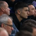 Ilias Koutsoupias kijkt aandachtig toe vanuit de tribune van het Lotto Park.