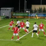 Spelers van twee beloftenploegen in actie tijdens een standaardsituatie voor doel.