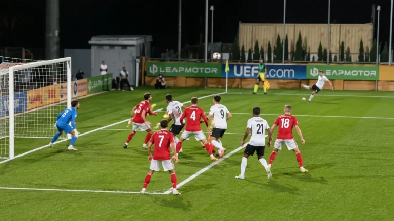 Spelers van twee beloftenploegen in actie tijdens een standaardsituatie voor doel.