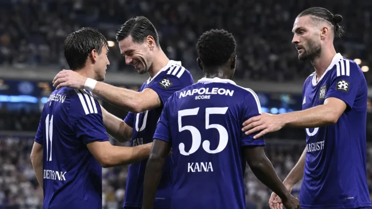 Anderlecht-spelers omhelzen elkaar na een wedstrijd in paarse tenues.