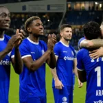 Een groep KAA Gent-spelers viert samen op het veld na een wedstrijd.