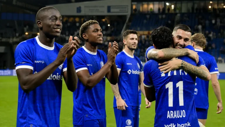 Een groep KAA Gent-spelers viert samen op het veld na een wedstrijd.