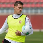 Lucas Stassin warmt op in Sevilla-trainingskleding op het trainingsveld.