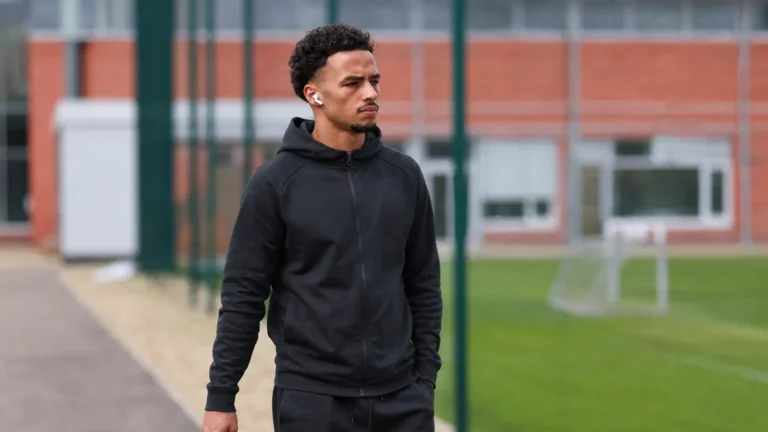 Chemsdine Talbi wandelt in neutrale sportkleding langs een trainingsveld.
