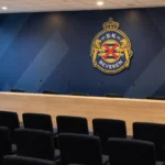 Lege communicatiehal in het clubgebouw van SK Beveren met een fysiek clubembleem aan de muur.