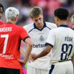 Een groep spelers van Club Brugge overlegt op het veld met een official.