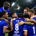 Een groep KAA Gent-spelers viert samen onder de stadionlichten.